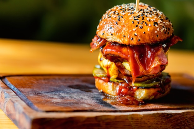 Freshly cooked delicious burger with minced meat and cherry served in restaurant. Fast food concept. Selective focus