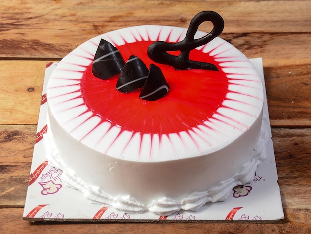 Freshly made cranberry cream cake on wooden table selective focus