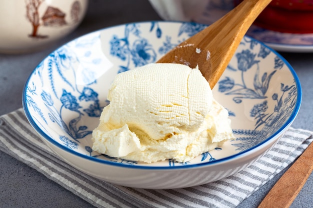 Freshly made homemade cream cheese in a plate selective focus Concept of homemade cheese making