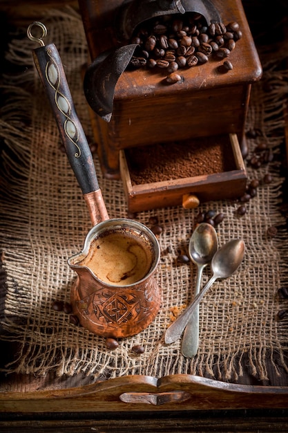 Freshly milled coffee with old grinder and pot boiled coffee