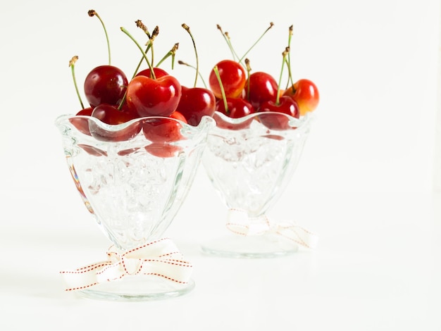 Photo freshly picked heap of cherries in glass dishes.