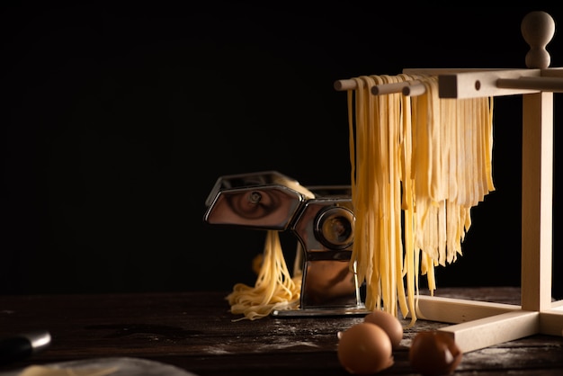 Freshly prepared Tagliatelle paste is dried on a wooden drier, Traditional italian cuisine