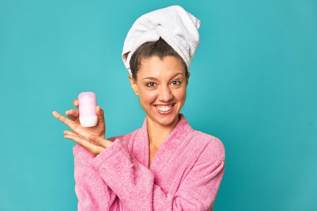 Freshly showered woman holding deodorant studio photo