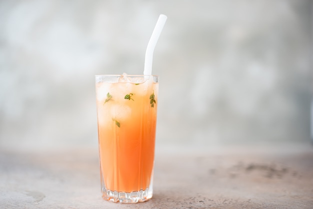 Freshly squeezed grapefruit juice with ice in a tall glass