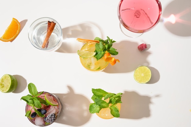 Freshness summer cocktails lemonade mai tai blackberry mojito with lime on white background with sunny shadow Summer beverage View from above