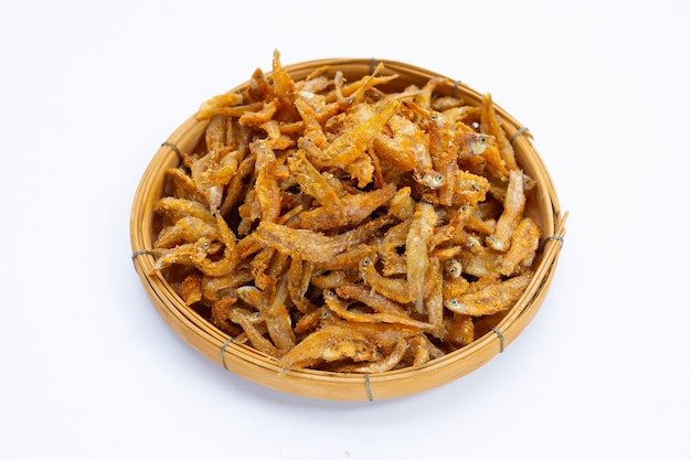 Fried Anchovies in bamboo basket on white background.