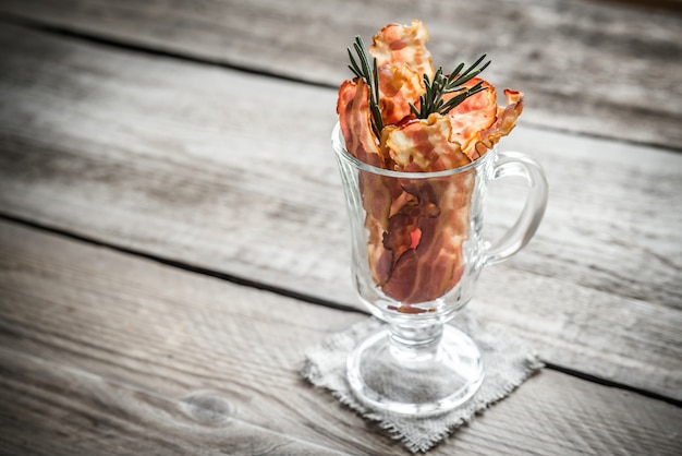 Fried bacon strips with fresh rosemary