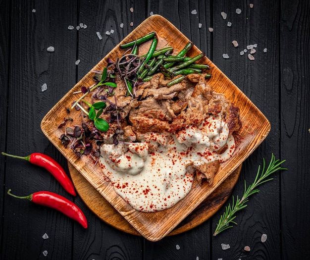 Fried beef slices with creamy sauce and asparagus beans