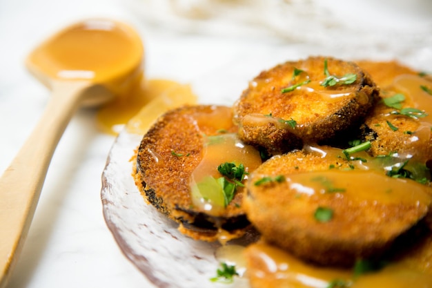 Fried breaded eggplant slices covered with honey