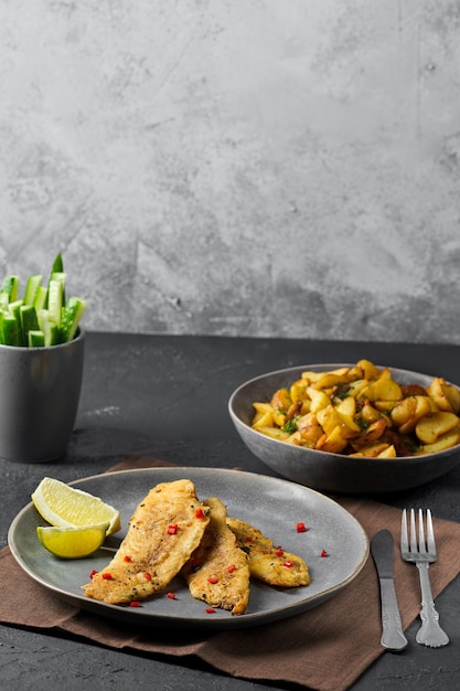 Fried breaded hake fillet with spice and roasted potato wedges