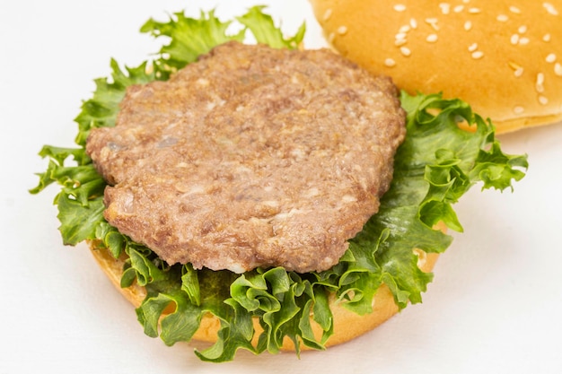 Fried burger bun on lettuce leaf Top view