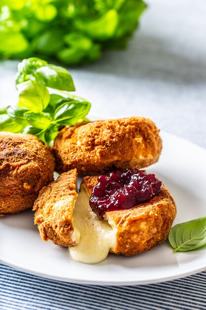 Fried camembert or brie cheese with cranberry jam and basil.