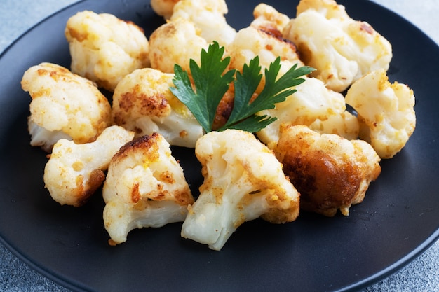 Fried cauliflower on a black plate