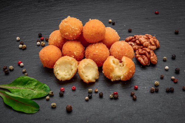 Fried cheese ball, cheese nuggets on a wooden plate