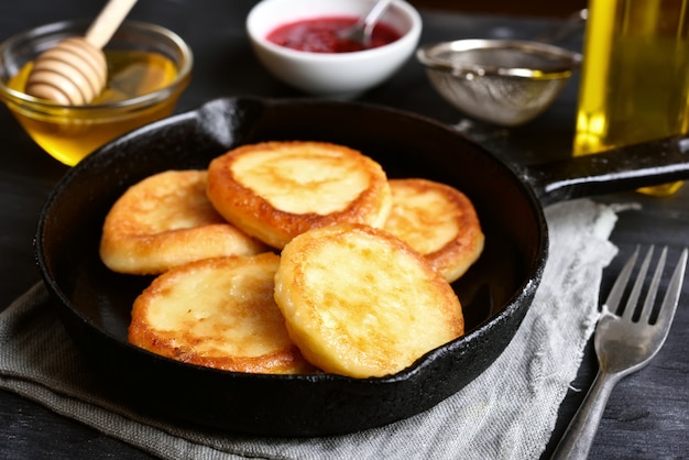 Fried cheesecakes in frying pan