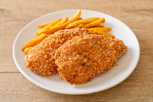 fried chicken breast fillet steak with French fries and ketchup