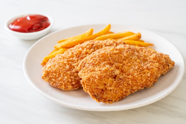 fried chicken breast fillet steak with French fries and ketchup