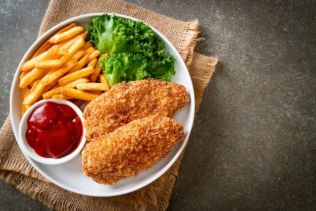 fried chicken breast fillet steak with French fries and ketchup