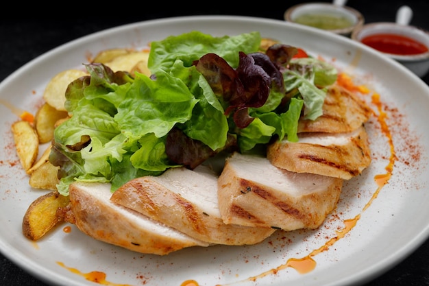 Fried chicken breast with grilled vegetables mixed greens and potatoes