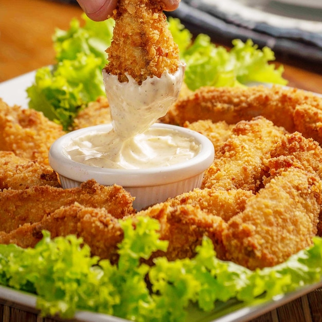 Fried chicken dish and chicken piece dipped in mayonnaise sauce