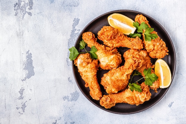 Fried chicken legs with lemon and parsley