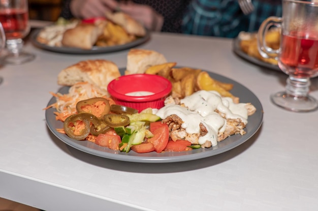 Fried chicken meat with French fries and fresh vegetables on a plate