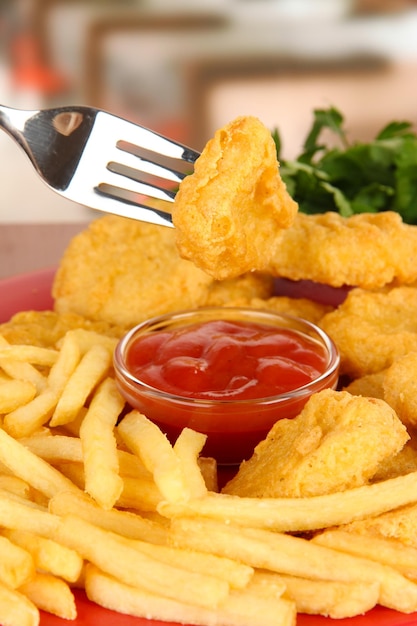 Fried chicken nuggets with french fries and sauce on table in cafe