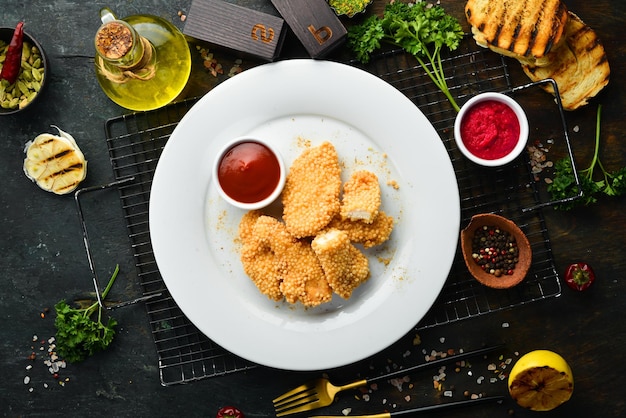 Fried chicken nuggets with ketchup sauce on a plate. Top view.