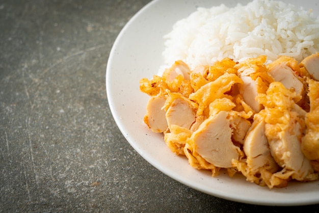 fried chicken topped on rice with spicy dipping sauce