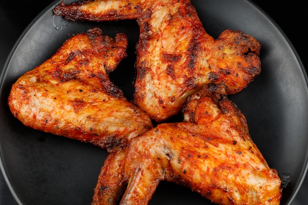 Fried chicken wings on a black plate