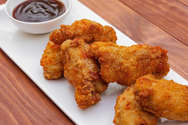 Fried chicken wings with barbeque sauce breaded crispy fried chicken on wooden table deep fried food