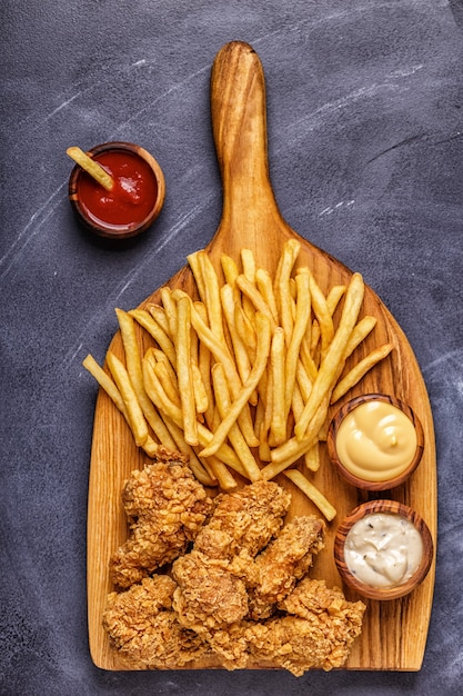 Fried chicken wings with french fries, top view.