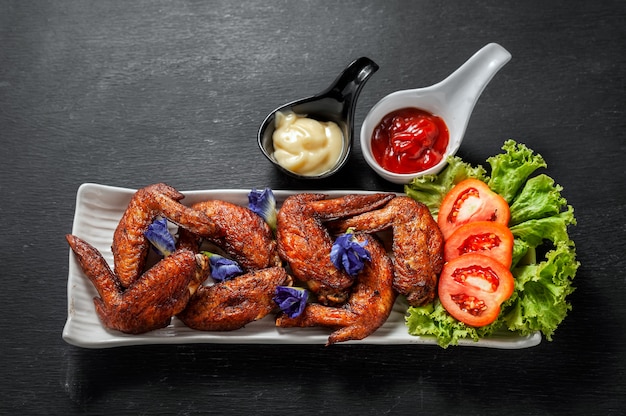 Fried chicken wings with ketchup and salad dressing