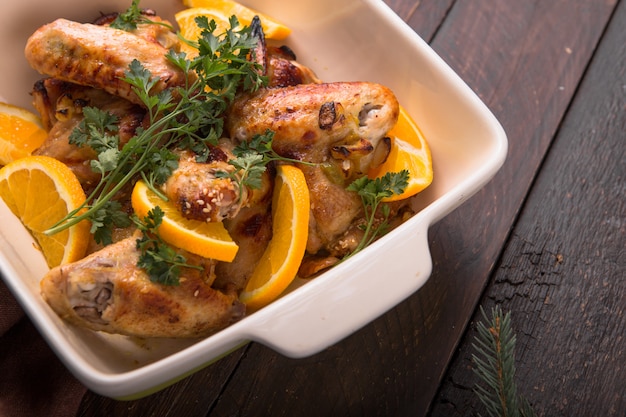 Fried chicken wings with orange slices