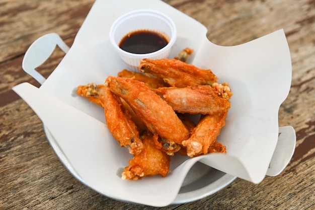 Fried chicken wings with sauce thai food on wooden table food background