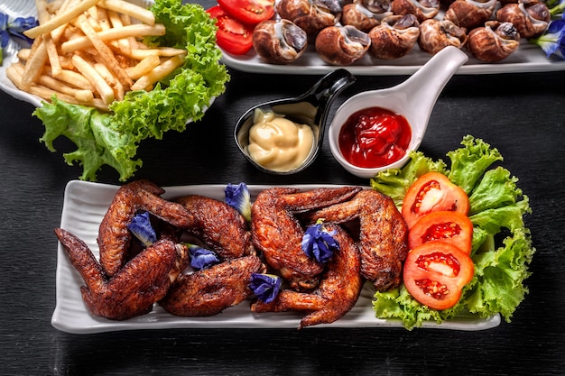 Fried chicken wings with streamed spotted Babylon and french fries