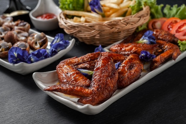 Fried chicken wings with streamed spotted Babylon and french fries