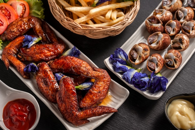 Fried chicken wings with streamed spotted Babylon and french fries