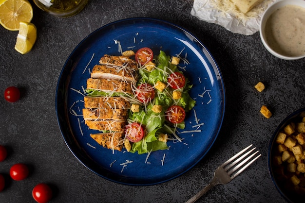 Photo fried chicken with salad like caesar top view black background