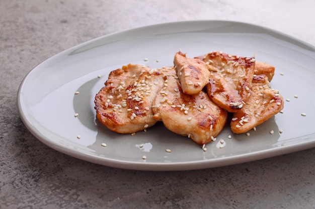 Fried chicken with soy sauce on a plate decorated with sesame seeds