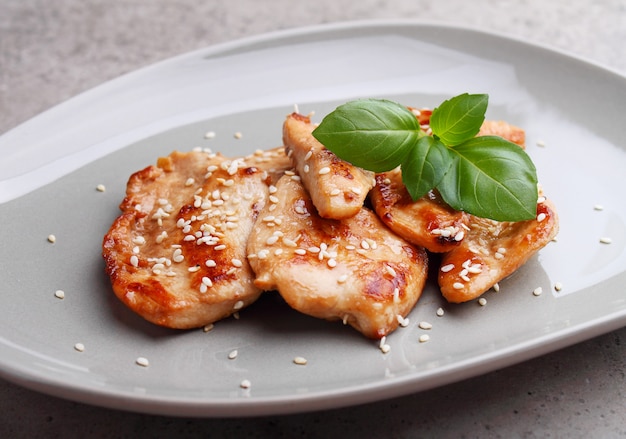 Fried chicken with soy sauce on a plate decorated with sesame seeds