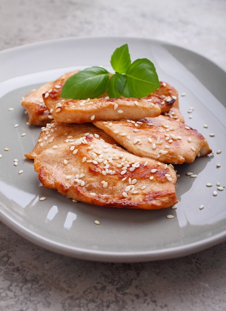 Fried chicken with soy sauce on a plate decorated with sesame seeds