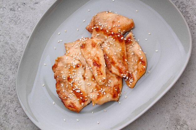 Fried chicken with soy sauce on a plate, top view