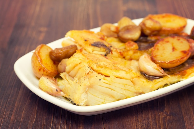 Fried cod fish with chestnuts and potato  on white dish