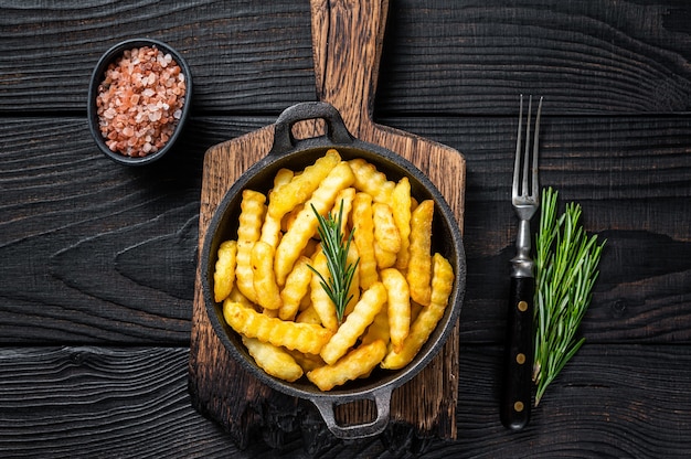 Fried Crinkle French fries potatoes in a pan