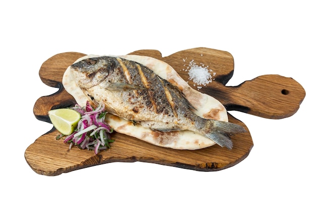 Fried dorado fish served on a wooden board with tortilla onion lemon and salt Appetizing mediterranean dish Closeup Isolated on white background