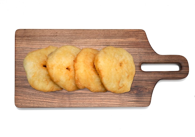 Fried doughnuts on wooden cutting board isolated on white background