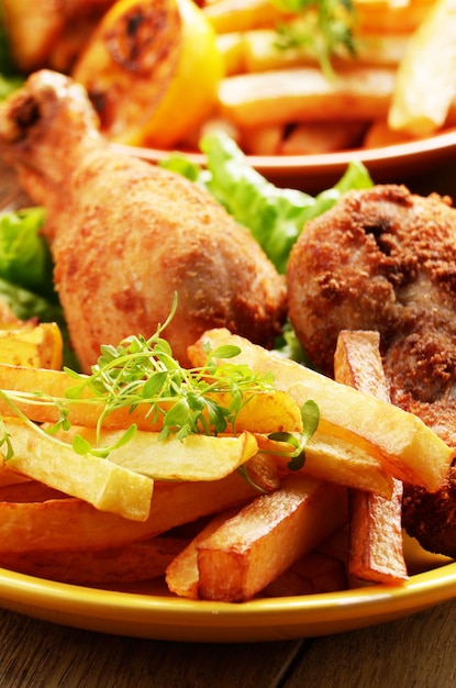 Fried drumsticks with french fries on the table