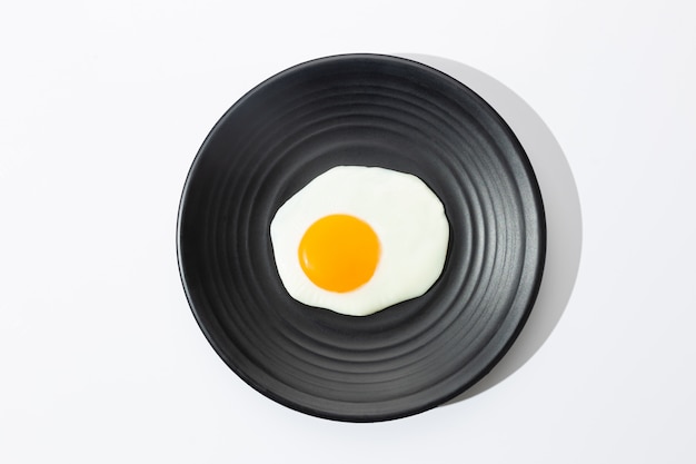 Fried egg on black plate.