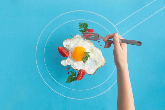 Photo fried egg food styling with tomatoes cherry and persil in pan drawn by chalk hand in taking a piece